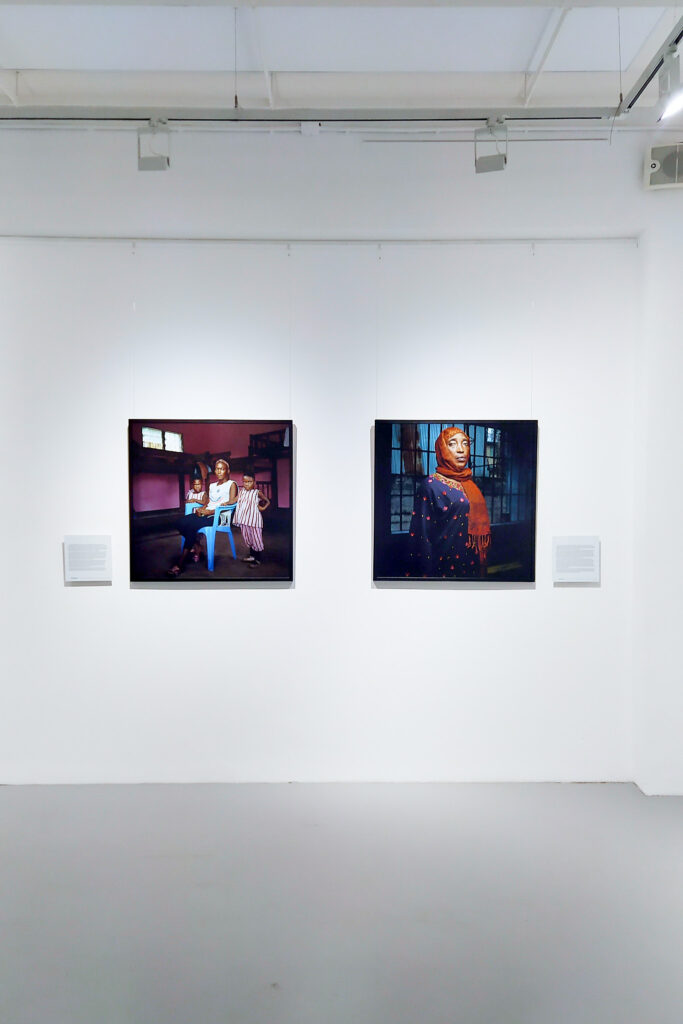 Vue de l'exposition Unsung Heroes par le photographe Denis Rouvre :  2 tirages photographiques sont accrochés sur un mur blanc. Les image représentent des femmes victimes de violences.